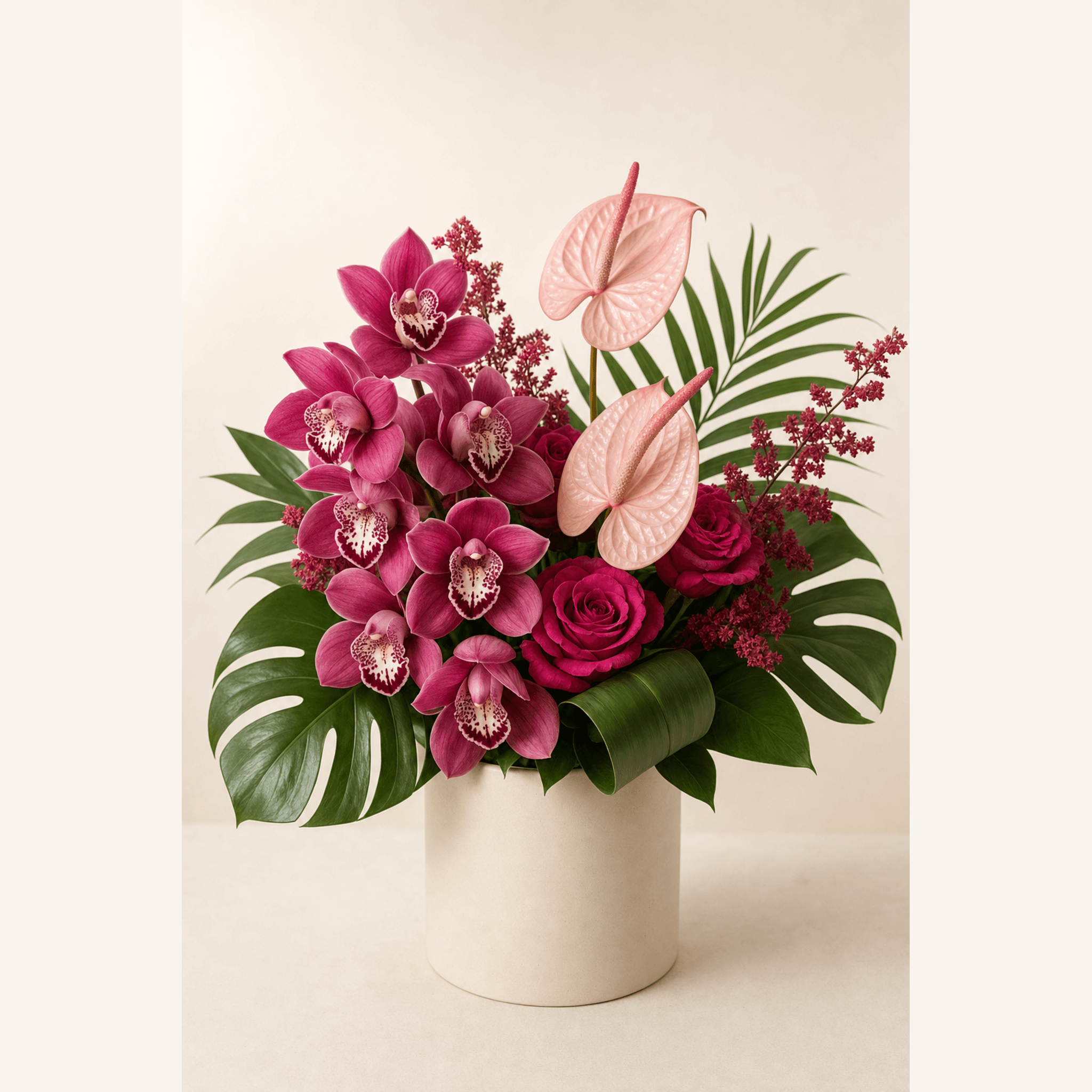 Pink anthuriums, magenta cymbidium orchids, deep pink roses and red astilbe in a cream ceramic pot